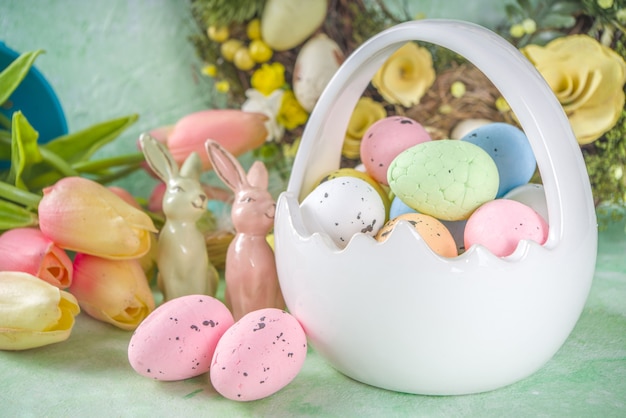 Happy Easter concept with easter eggs in basket and spring flowers. Easter background with copy space and photo frame