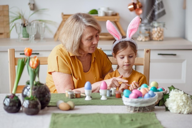 Happy easter family elderly grandmother and little granddaughter with rabbit ears