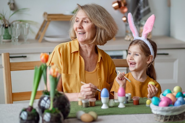 Happy easter family elderly grandmother and little granddaughter with rabbit ears