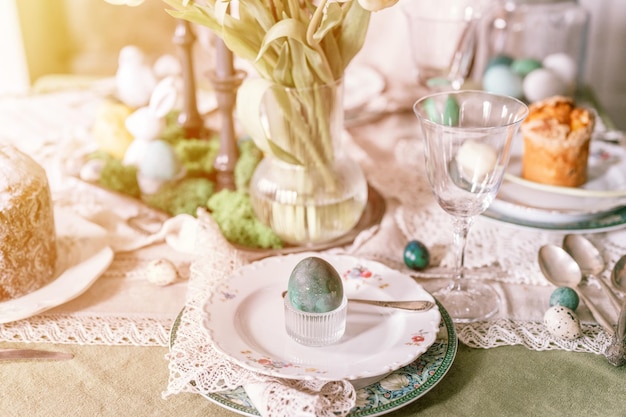 Happy easter holiday in springtime painted green emerald colored chicken egg in bowl and plate on table festive home decor traditional food sophisticated country rustic tablescape style flare