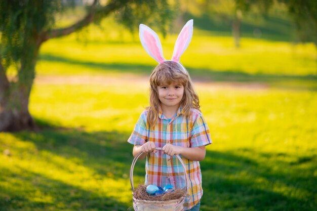 Happy Easter Kids boy in bunny ears hunting easter eggs in park outdoor