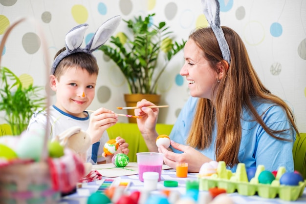 Happy easter a mother and her son painting easter eggs