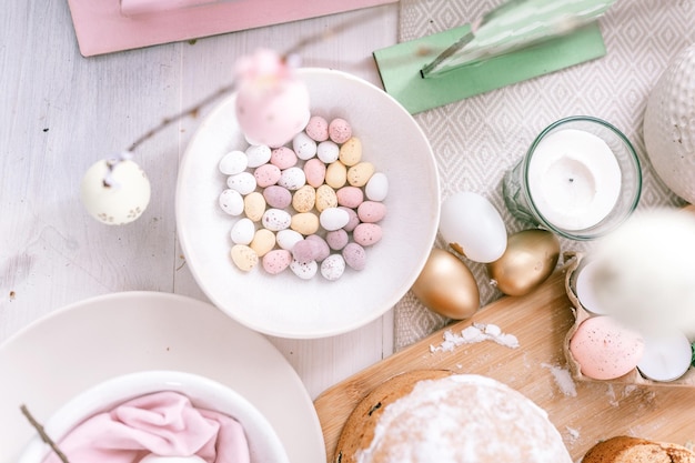 Happy easter and spring holidays time festive tablescape set decor traditional dinner food easter eggs and baked cakes on table at home pale pop pastel blue and pink color top view