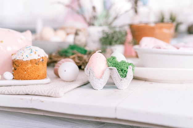 Happy easter and spring holidays time festive tablescape set decor traditional dinner food easter eggs and baked cakes on table at home rabbit and willow pale pop pastel blue and pink color