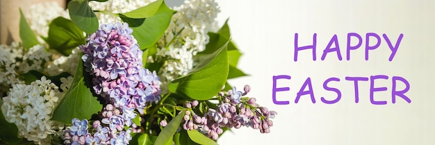 Happy easter text sign greeting card spring flat lay purple lilac flowers on white background flat l