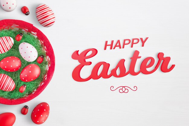 Happy easter text on white surface with eggs basket and ladybug decorations beside