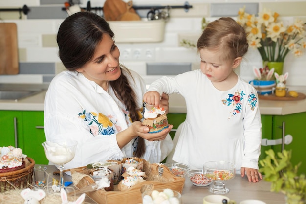 Happy easter with family Mother and daughter together cook and decorate easter cake in home kitchen