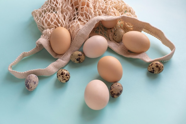 Happy Easter zero waste concept Natural rustic eggs in a string bag on a blue background The minimal concept An Easter card with a copy of the place for the text