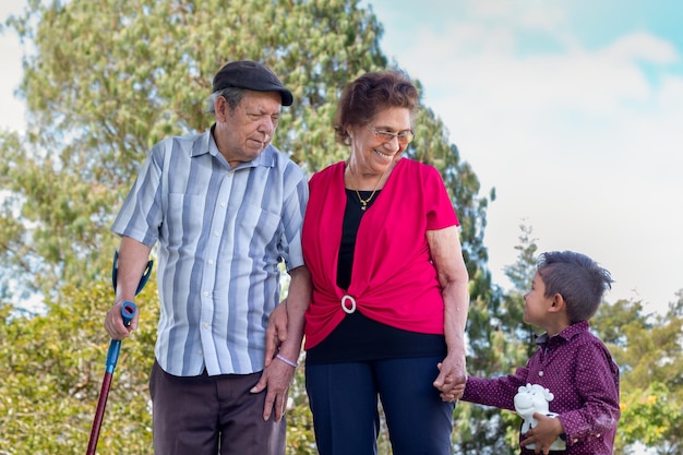 Happy elderly couple holding hands with their great grandchild