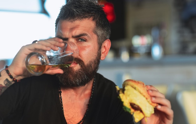 Happy elegant man drinking beer Portrait of handsome young man tasting a draft beer Enjoy in pub