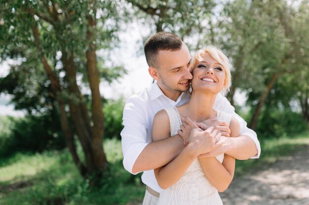 Happy Embrace of Newlywed Couple in Sunlit Outdoor Setting