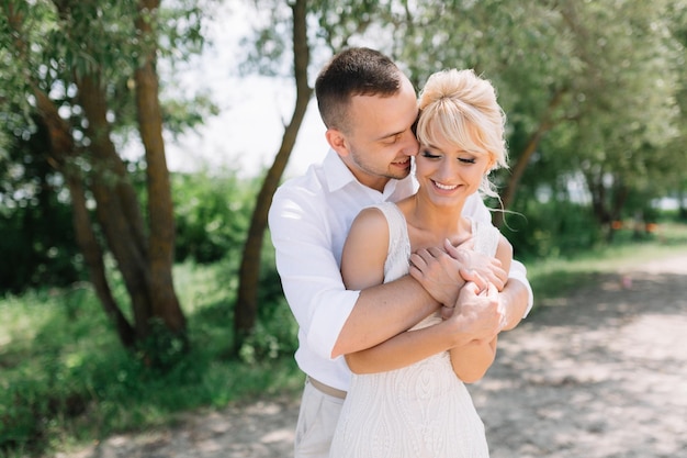 Happy Embrace of Newlywed Couple in Sunlit Outdoor Setting