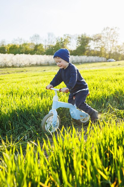 Happy emotional child A cheerful boy walks on a children's jogging track on the green grass in the garden Running track for children