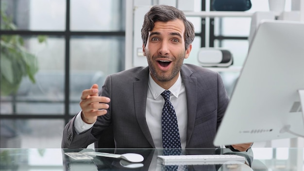 Happy emotional man in the office working with a computer