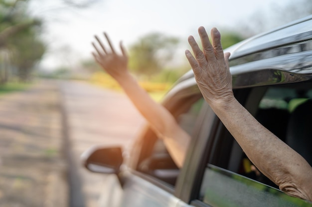 Happy enjoy and freedom in traveling trip with raised mother hand out of window car in summer vacation holiday