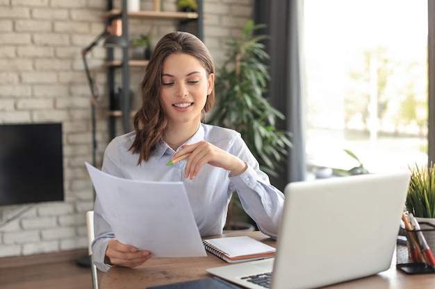 Happy entrepreneur woman sit at desk reading good news in post paper correspondence.