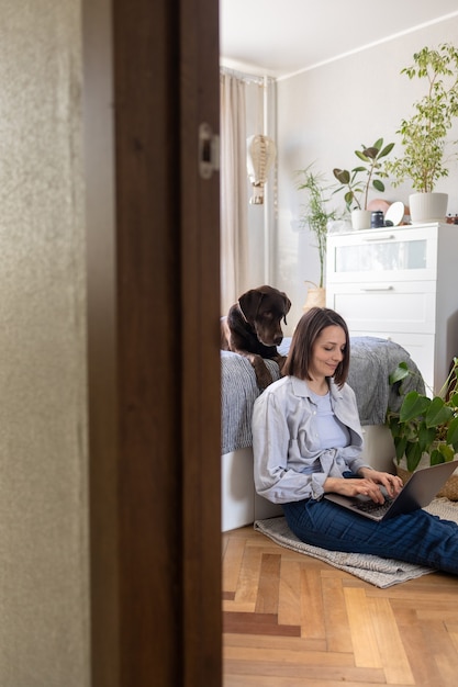 Happy european woman and her labrador retriever dog at home