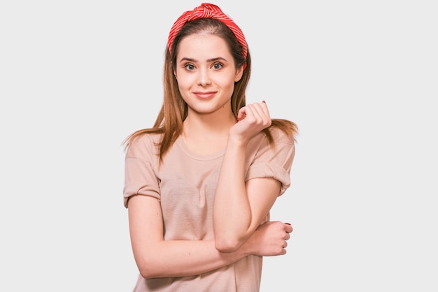 Happy European woman smiling feels excitement being in high spirit posing against white background Pretty female has joyful expression wearing red headband