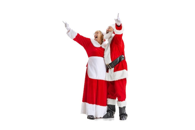 Happy and excited Mr and Mrs Claus pointing upwards