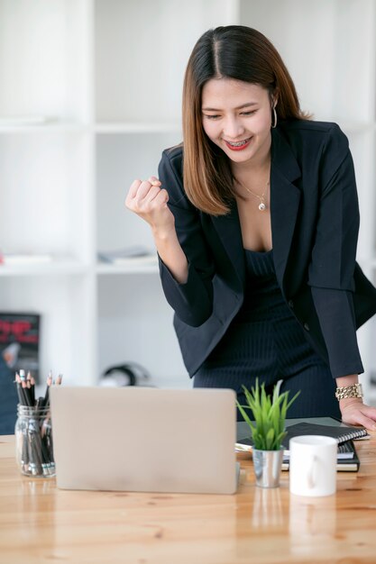 Happy excited successful businesswoman triumphing while working in modern office.