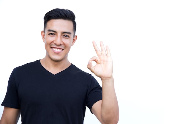 Happy excited young man making okay sign with fingers