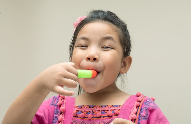 Happy face girl to eating ice cream, close up shot with copy space.