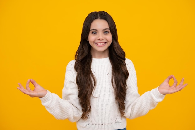 Happy face positive and smiling emotions Teenager child in white shirt hold hands in yoga om aum gesture relax meditate try calm isolated on yellow background