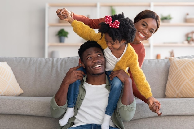 Happy family african american parents having fun with their daughter at home