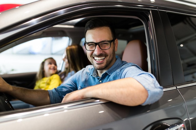 Happy family buying a new car at the car showroom.