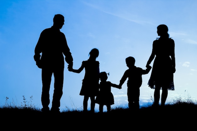 Happy family by the sea on nature silhouette