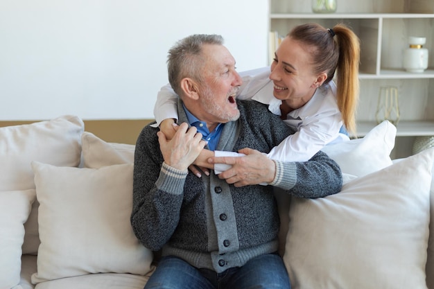 Happy family caring grown up daughter hugging loving older man father young woman embracing dad gran