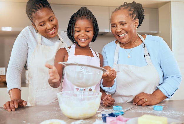 Happy family child and cooking in kitchen together for bonding or learning development activity Black family grandmother and mother teaching kid baking skills for independence in retiement home