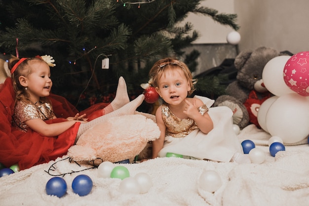 Happy family children celebrating New Year and Christmas at decorated Christmas tree and garlands