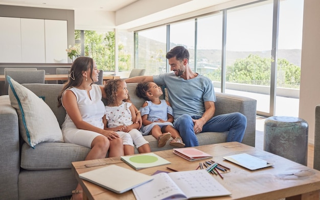 Happy family children and parents talking on a sofa relax and bonding in a living room at home Love quality time and affection by interracial family enjoy the weekend and conversation in a house