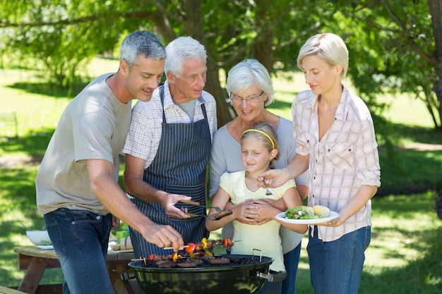 Happy family doing barbecue in the park 