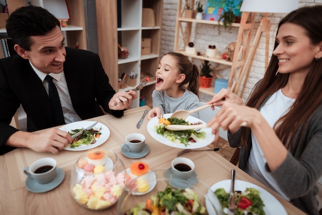 Happy family eating dishes at the table together