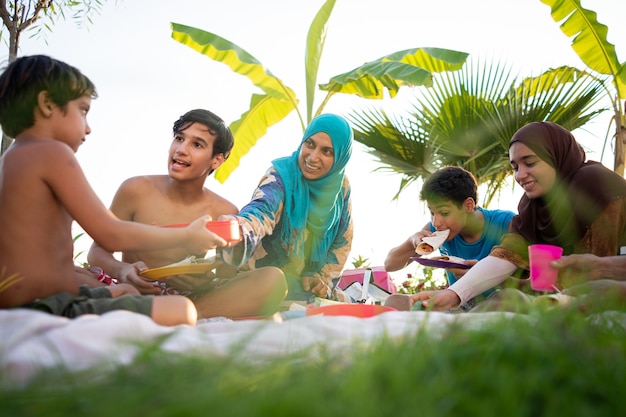 Happy family enjoying picnic on beach near sea