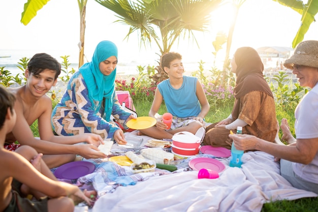 Happy family enjoying picnic on beach near sea