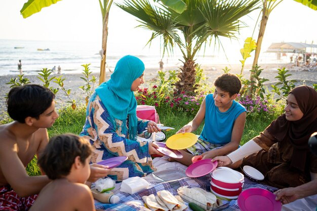 Happy family enjoying picnic on beach near sea