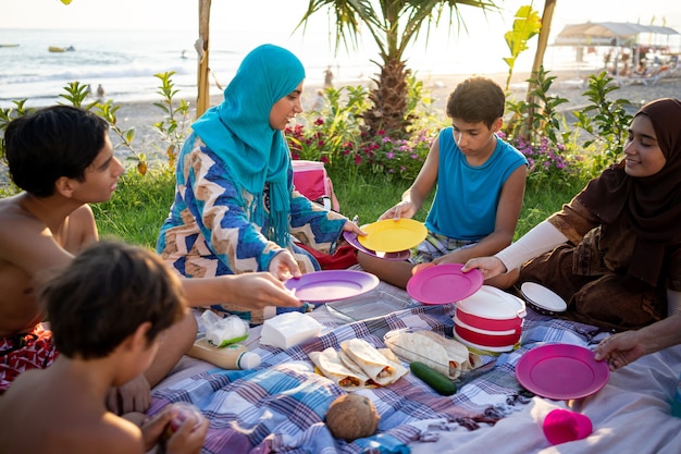 Happy family enjoying picnic on beach near sea