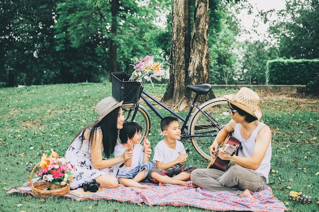 happy family enjoying on their picnic in public park .couple and sons having a good time.