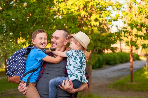 Happy family of father and children.The father holds the children in his arms