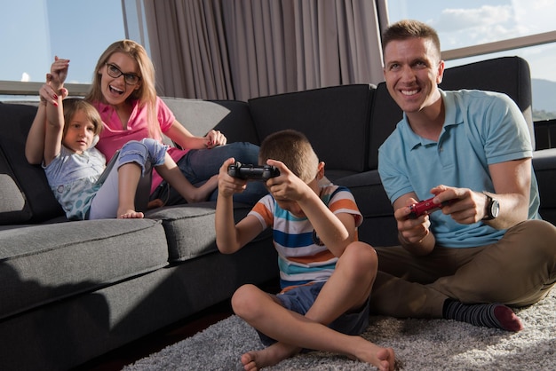 Happy family. Father, mother and children playing a video game Father and son playing video games together on the floor