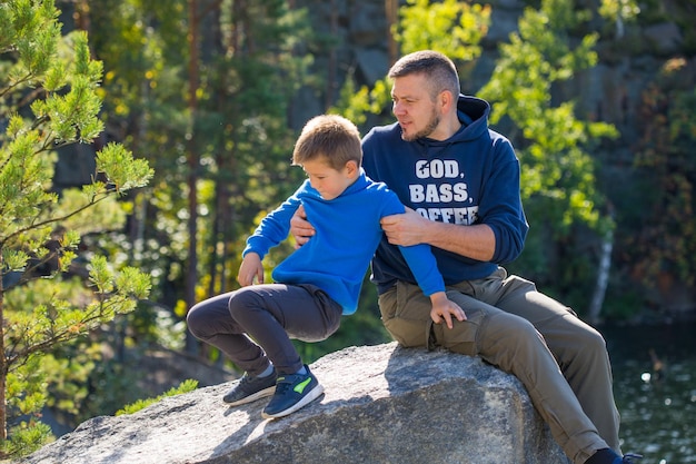 Happy family Father playing with son oudoors Positive human emotions feelings joy on the lake in Korostyshiv quarry Zhytomyr district northern Ukraine