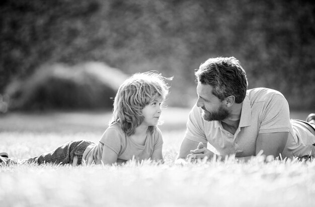 Happy family of father and son child relax in summer park green grass family day