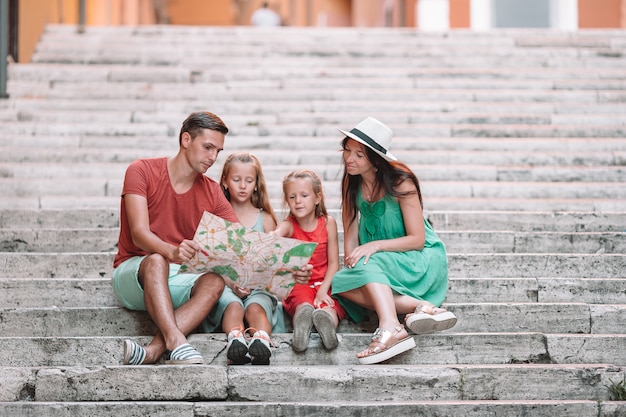 Happy family of four in Rome with map