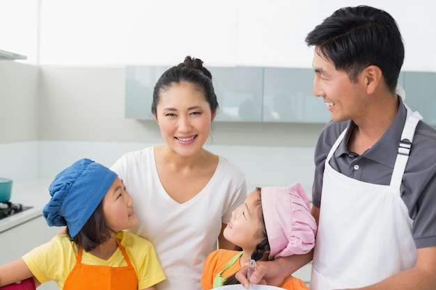 Happy family of four smiling in kitchen