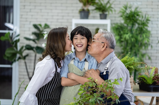 Happy family gardening together in the garden grandfather grandson and woman taking care of nature