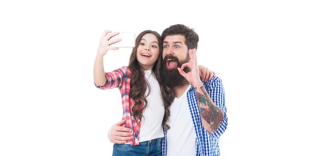 Happy family girl child and bearded man take selfie with mobile camera phone isolated on white OK