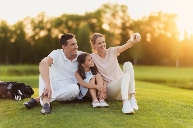 Happy Family Has Rest after Golfing Takes Selfie.